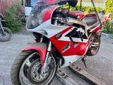 a red and white motorcycle parked in a parking lot
