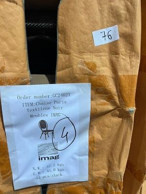 un bout de papier collé à l'arrière d'une chaise, sur lequel est accrochée une affichette
