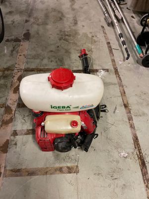 a red and white sprayer sitting on the floor