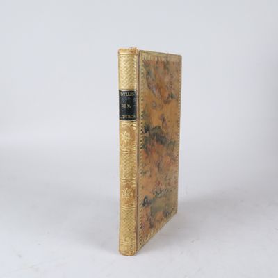 un vieux livre posé sur une table blanche à côté d'un mur blanc