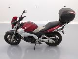 a red and black motorcycle parked in a white room
