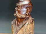 wooden bust of a man with a beard sitting on a wooden table