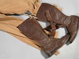 pair of brown boots sitting on top of a pair of tan pants
