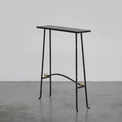 une table noire avec un piètement en métal et un plateau en bois