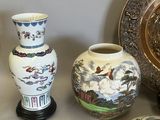 three vases sitting on a table next to a plate