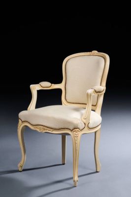 a white chair with a beige upholstered back and arms