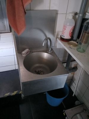 un évier dans un coin de la cuisine, avec une serviette suspendue au-dessus