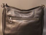 the black leather purse is sitting on the table next to a bottle of water