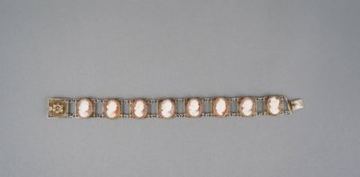 un gros plan d'un bracelet posé sur une surface grise