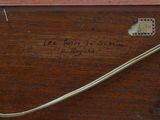 a piece of wood with writing on it and a metal handle