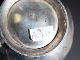 a silver vase that has a tag on it