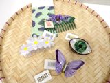 purple and white hair accessories on a bamboo tray on a table