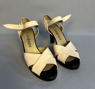 une paire de sandales blanches et noires à talon noir