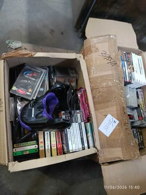 a cardboard box full of books and dvds on the floor
