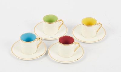 four cups and saucers are sitting on a white surface