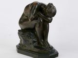 statue of a man sitting on a rock with his head in his hands