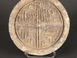 un gros plan sur un objet en pierre orné d'une croix