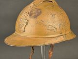 an old yellow fire helmet on a metal stand against a gray background