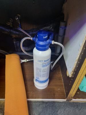 une bouteille d'eau posée par terre à côté d'un rouleau de tissu