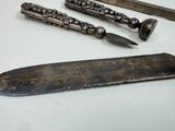 three different types of knives on a white table