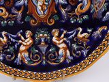 a blue and orange plate with angels and cherensils on it