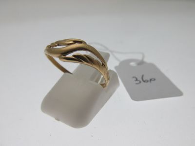 une image représentant une bague en or posée sur une surface blanche
