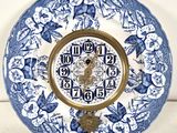 a blue and white plate with a clock on it