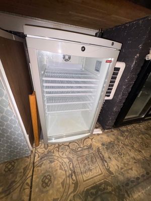 a small refrigerator with a door open on the floor