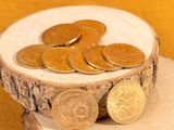 a pile of coins sitting on top of a piece of wood
