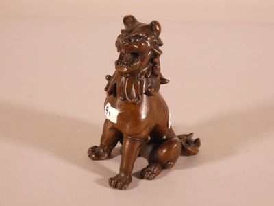a bronze statue of a lion sitting on the ground