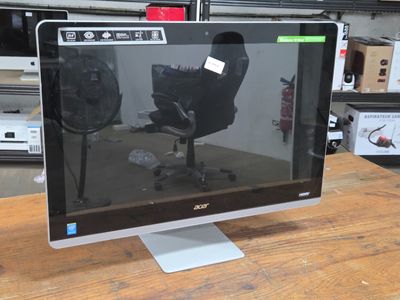 un écran d'ordinateur posé sur une table en bois