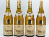 four bottles of wine are lined up on a white surface