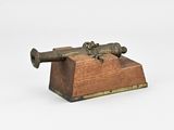 une petite boîte en bois surmontée d'un canon