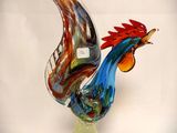 a glass sculpture of a rooster on a glass base