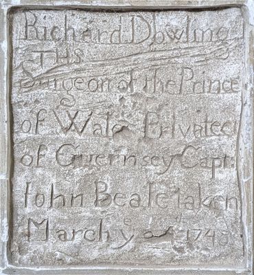 an old stone plaque with writing on it in front of a building