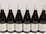 six bouteilles de vin rouge sont alignées sur une table