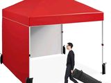 a man walking under a red tent with a suitcase
