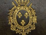 an old book with a crown on top of it sitting on a table