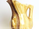 a brown and white vase sitting on a white surface