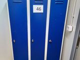 deux casiers bleus dans des toilettes, avec une pancarte sur la porte