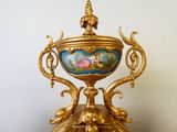 un vase en or orné d'une peinture, posé sur une table
