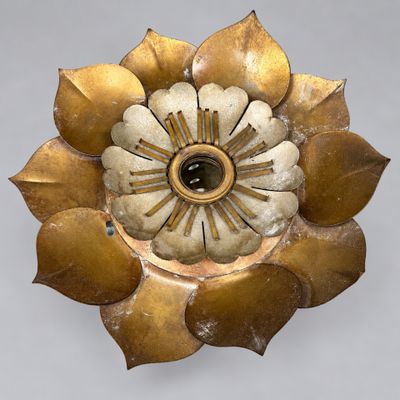 a gold flower with a black center on a white background