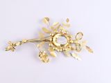 a gold flower brooch on a white background