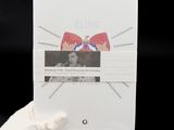 a person in white gloves holding a book with a picture of a cat on it