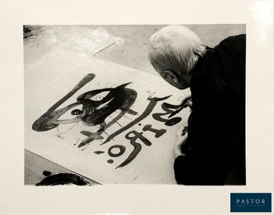 a black and white photo of a woman painting a picture