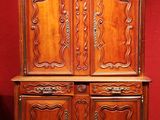 an old wooden cabinet with carvings on the top of it