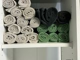 a white shelf with towels and towels in it