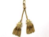 two tassels hanging from a hook on a white background