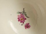a white bowl with a pink flower on it
