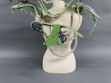 a white vase with green and blue decorations on it